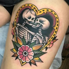 a woman's thigh with a skull and flower tattoo on it