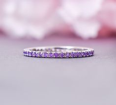 a close up view of a wedding band with purple stones