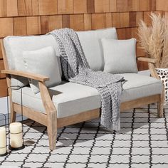 a white couch sitting on top of a wooden floor next to a vase filled with flowers