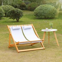 an empty lounge chair and table in the grass