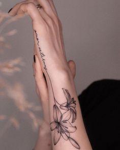 a woman's arm with a flower tattoo on the left side of her hand