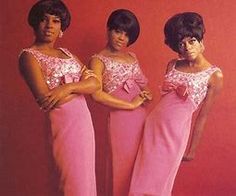 three women in pink dresses standing next to each other with their hands on their hips