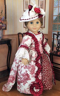 the doll is wearing a red and white dress