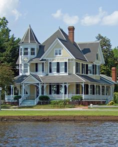 a large white house sitting next to a body of water