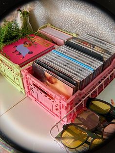 a bunch of cds sitting on top of a table next to sunglasses and a book