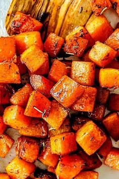 roasted sweet potatoes on a white plate with a wooden spoon