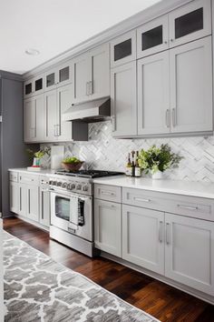 a kitchen with white cabinets and wood floors