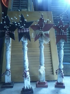 three wooden pillars decorated with red and white stars, tied with twine bows on each pillar