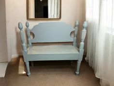 a blue bench sitting in front of a window next to a white curtained wall