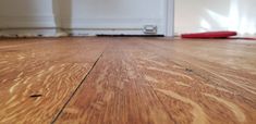 a close up view of a wood floor with a red object on the ground next to it