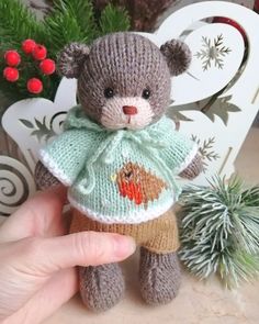 a small teddy bear is wearing a sweater