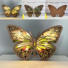 three wooden butterflies sitting on top of a shelf next to each other with lights in them