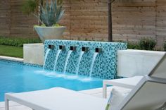 an outdoor pool with water features and lounge chairs