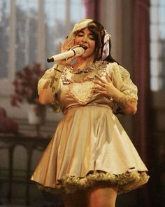 a woman in a dress singing into a microphone