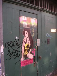 a door with graffiti on it and a woman's face painted on the side