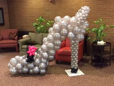 an inflatable balloon dog is on the floor next to a couch and chair