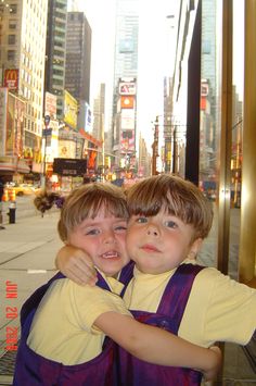 two young boys hugging each other in the city