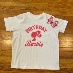 a white shirt with the words birthday barbie on it and a pink bow in front