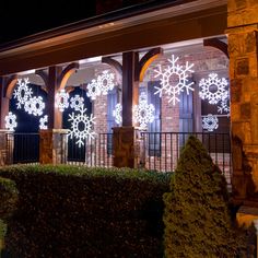 lighted snowflakes on the windows of a building at night