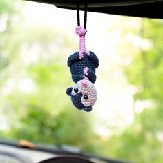 a crocheted stuffed animal hanging from a car dashboard