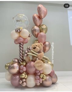 a teddy bear sitting on top of balloons