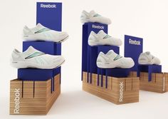 three stacks of reebok shoes sitting on top of each other in front of a white background