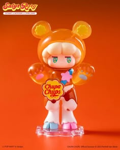 an orange and white toy with ears on it's head, holding a sign that says chupa chups