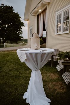 a wedding cake sitting on top of a table in front of a building with windows