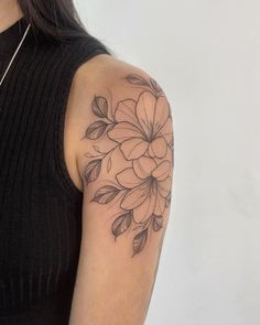 a woman's arm with a flower tattoo on the left side of her arm