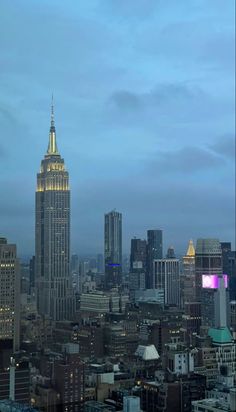 the empire building in new york city is lit up at night, as well as other skyscrapers