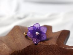 Sterling Silver Adjustable Fresh Purple Hydrangea Flower Ring, Preserved Flower Ring, Fresh Flower, Delicate Blossoms at Your Fingertips Size: 2cm x 2cm ( Due to the handmade nature of this ring, slight variations in size.) Celebrate the enchanting beauty of nature with this Sterling Silver Adjustable Fresh Purple Hydrangea Flower Ring. Handcrafted with care, this adjustable ring features a genuine purple hydrangea flower that has been meticulously preserved, capturing the allure of flourishing gardens. Each ring is a wearable piece of botanical art that adds a touch of natural elegance to your hand. Designed with your comfort in mind, this Sterling Silver Adjustable Fresh Flower Ring features an adjustable band, ensuring a perfect fit for any finger. The flexibility of the band adds to th Purple Flower Shaped Gemstone Jewelry, Purple Flower-shaped Handmade Jewelry, Purple Flower-shaped Whimsical Jewelry, Handmade Purple Flower-shaped Jewelry, Purple Flower-shaped Jewelry With Pressed Flowers, Real Rose Petals, Purple Hydrangea, Hydrangea Purple, Sakura Flower