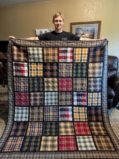 a man is holding up a blanket made out of many different plaids on it