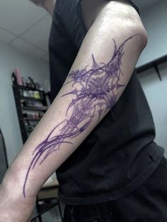 a man with a tattoo on his arm that has purple ink in the shape of a dragon