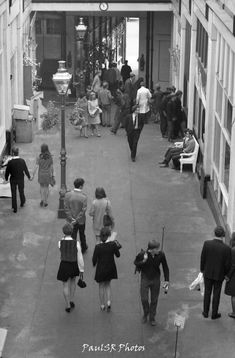 black and white photograph of people walking down the street