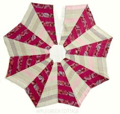 an open umbrella with pink and white designs on it