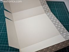 an open box sitting on top of a cutting mat with paper cut out to look like waves