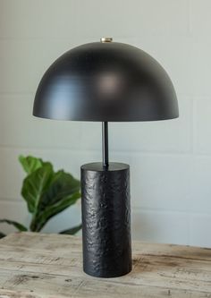 a black lamp sitting on top of a wooden table