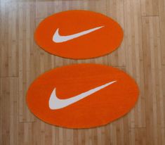 two orange and white rugs with the nike logo on them are sitting next to each other