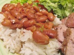 a plate with rice, beans and lettuce next to a salad on the side