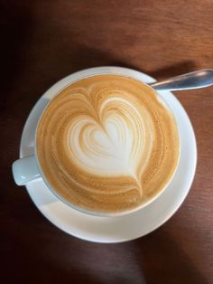 a cappuccino in a white cup with a heart drawn on the foam