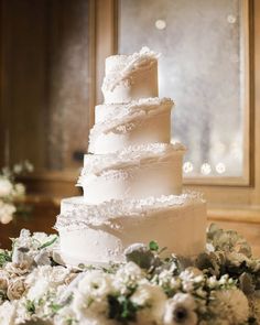 a wedding cake with white flowers and greenery