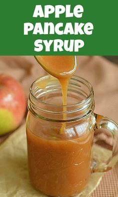 an apple cider syrup being poured into a mason jar