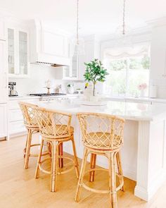 two wicker bar stools sit at the center of a kitchen island