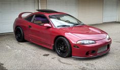 a red sports car parked in front of two garage doors