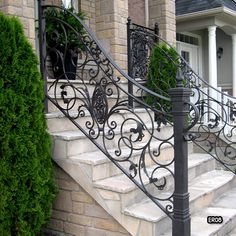 a wrought iron stair rail with planters on the steps in front of a house