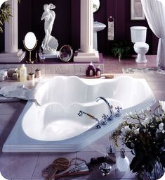 a large bathroom with purple walls and white fixtures, including a bathtub in the center