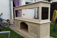 a dog house built into the side of a lawn with a bicycle parked next to it