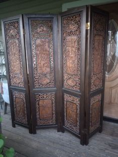 an ornate wooden room divider sitting on top of a wooden floor