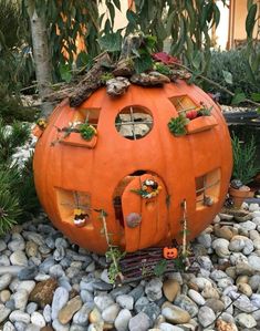 an orange pumpkin shaped house sitting on top of some rocks