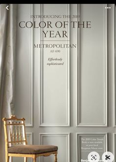 a chair sitting in front of a white wall with the words, color of the year metropolitan